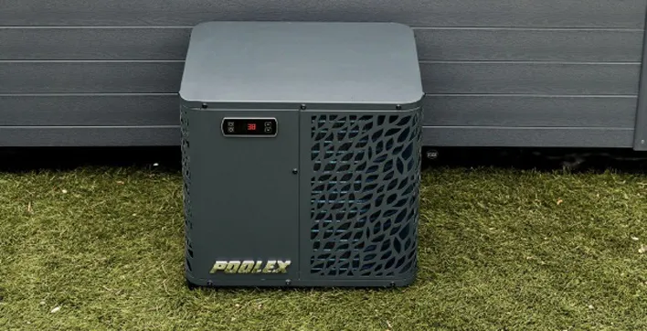 Photo d'une pompe à chaleur compacte de la gamme Poolex Spawer, probablement installée à côté d'un spa. L'appareil est moderne et conçu pour optimiser l'efficacité énergétique.