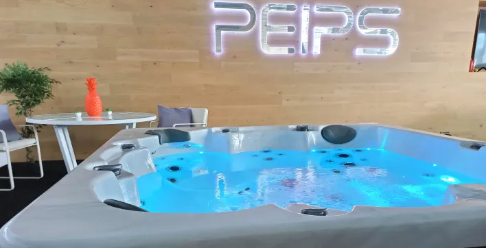 Un grand spa avec couverture de protection et commande à distance